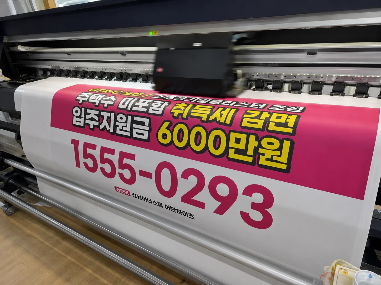 출력기에서 분양 광고 출력물이 나오고 있는 장면
