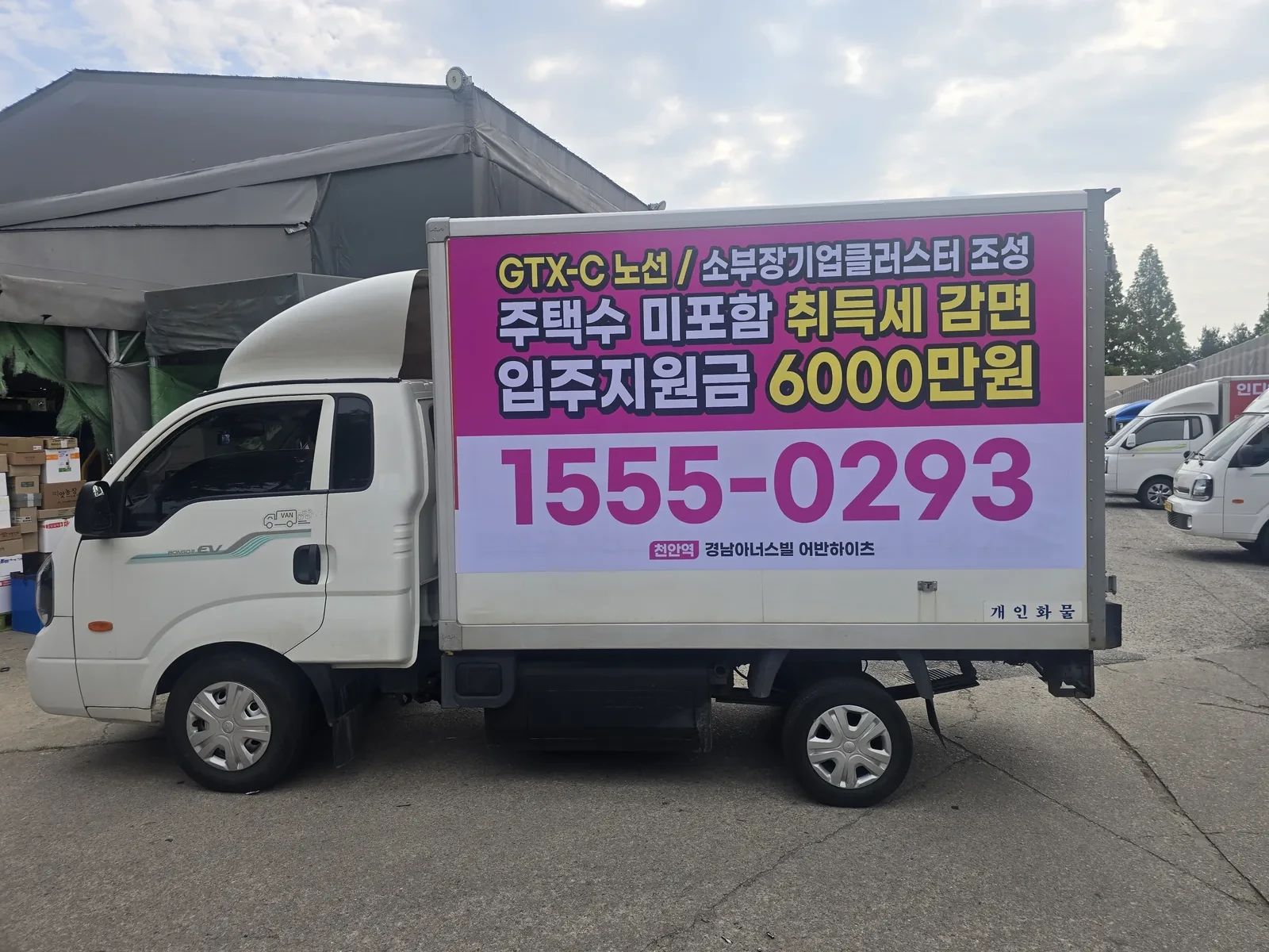 분홍색 바탕에 분양 조건을 큰 글씨로 넣은 광고 탑차의 측면 전체