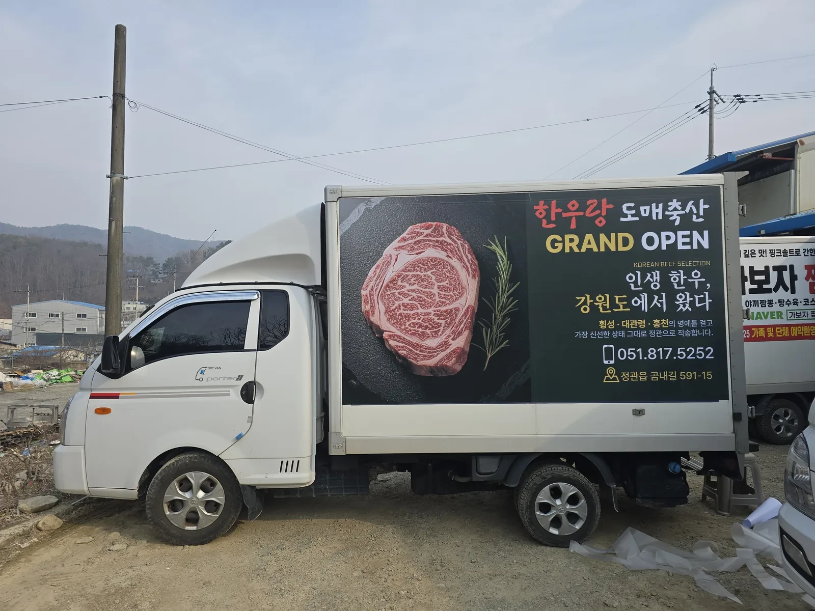 검은 바탕에 한우 사진을 크게 넣은 한우랑 도매축산 탑차 측면